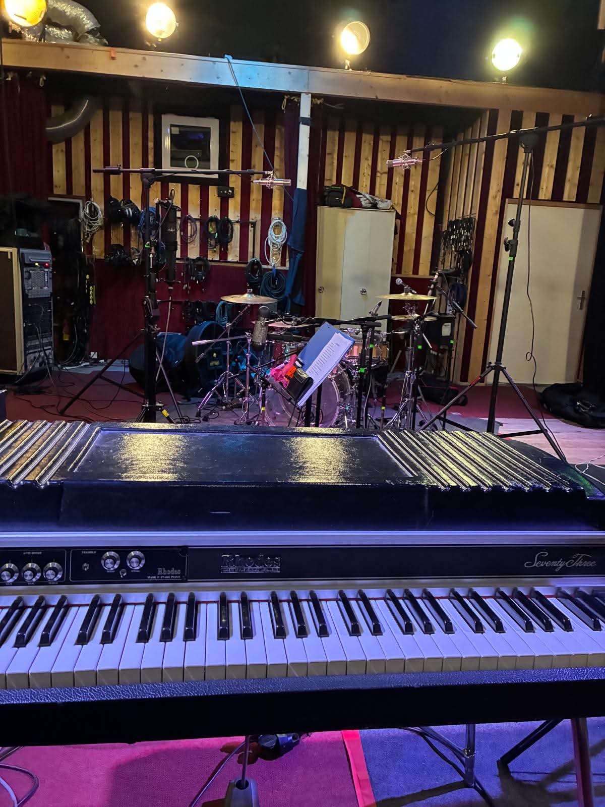 Studio d'enregistrement avec clavier Rhodes, batterie et micros